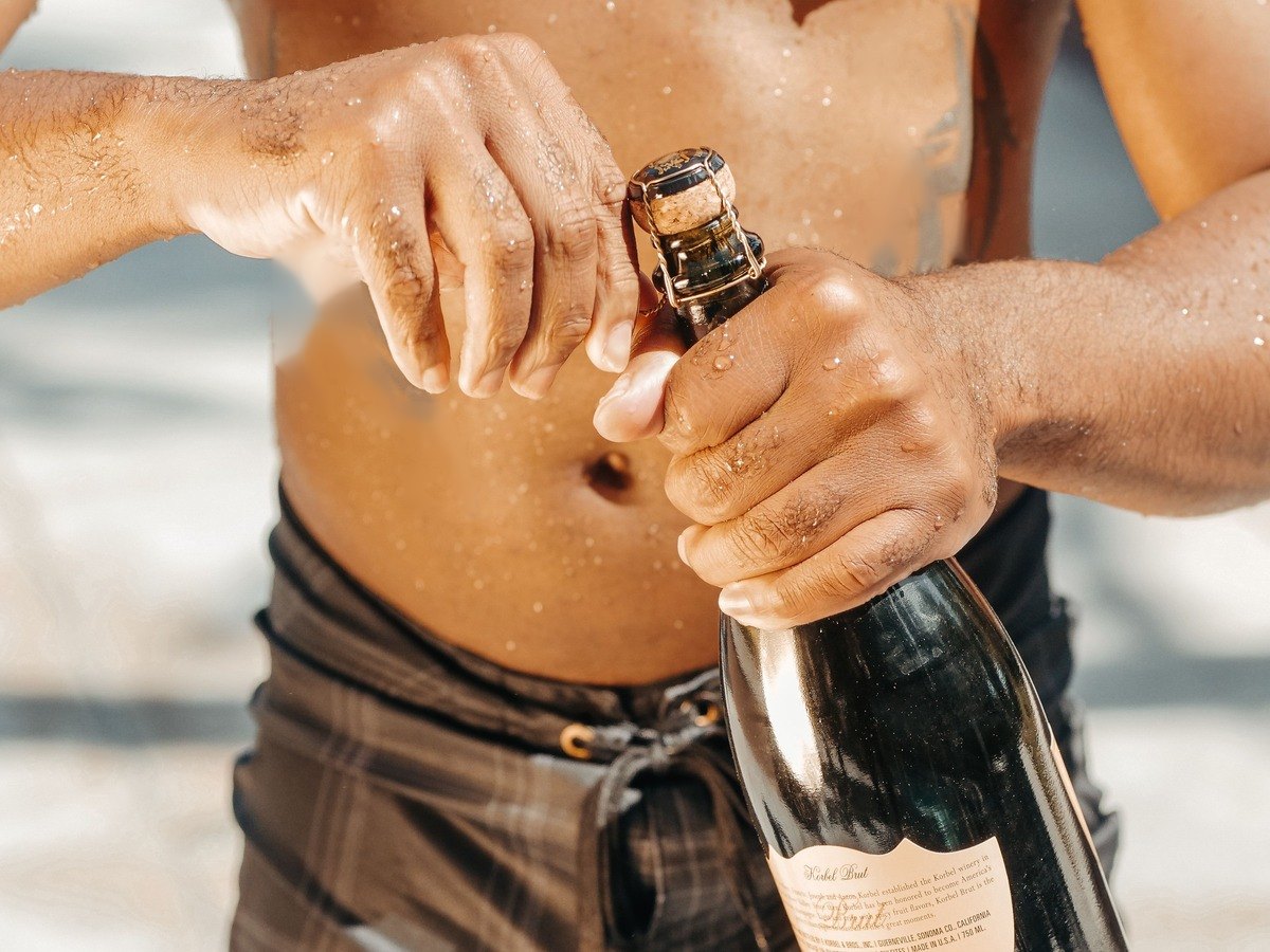 Shirtless bartender pouring drinks