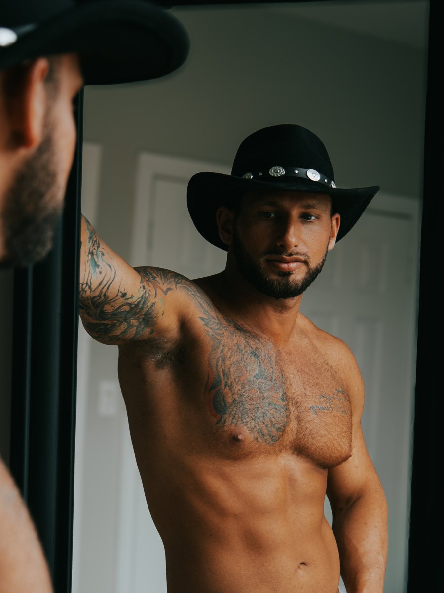 Parker Savage in a black cowboy hat and white shorts, mirror shot